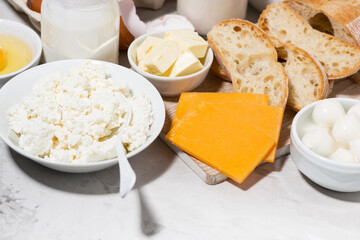 assortment of fresh farm dairy products on white table, top view