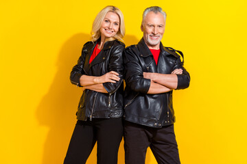 Portrait of attractive pensioner cheery grey-haired lovers folded arms isolated over bright yellow...
