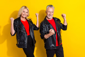 Portrait of attractive cheerful cool lucky grey-haired spouses rejoicing isolated over bright yellow color background