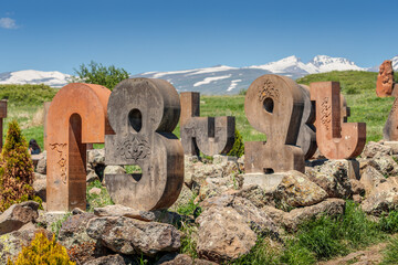 Armenian alphabet monument with stone sculptures of letters and Mesrop Mashtots
