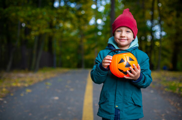 boy in autumn park with halloween pumpkin.