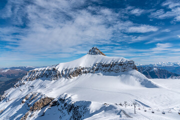 A winter day on the Diablerets glacier at 3000 meters above sea level in Switzerland with a blue sky with clouds.