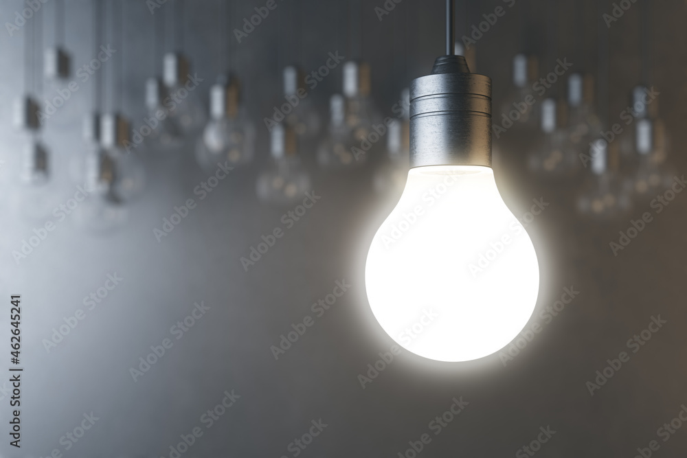 Poster glowing light bulb on blurry concrete wall backdrop. idea, innovation, solution and invention concep