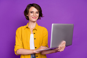 Portrait of attractive cheery skilled experienced girl using laptop it startup isolated over bright violet purple color background