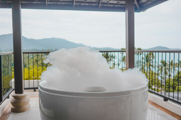 Bathtub with soap bubbles, Luxury jacuzzi suite for relaxation on balcony with landscape of sea view, Samui, Thailand - obrazy, fototapety, plakaty