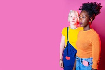 Two young diverse multicultural caucasian and black women best friends posing isolated advertising copy space background