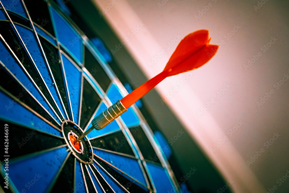 Poster close up shot of the dart arrow hit on bulleyes of dartboard to represent that the business reached 