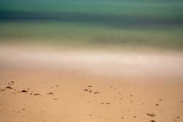 Long exposure ocean waves on sandy shores