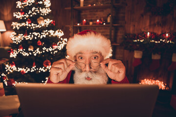 Photo of cute shocked age santa claus wear red costume arms spectacles reading modern gadget...