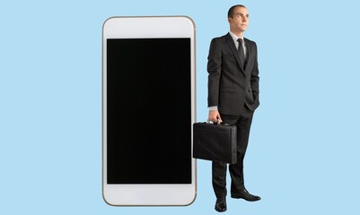 Full length of young guy leaning on giant mobile phone with an empty screen,