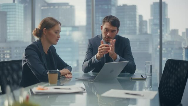 Corporate CEO and Investment Manager Talking, Using Laptop Computer while Sitting in Meeting Room in Office. Two Successful Businesspeople Fist Bump Over a Lucrative Real Estate Investment Deal.