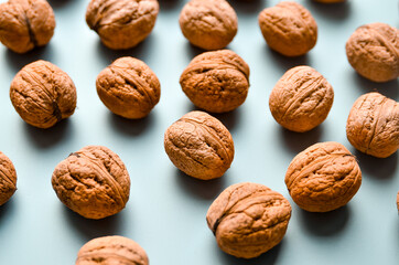 Walnuts on grey background as pattern, flat lay with copy space.