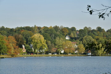 Le lac de Genval dans un cadre bucolique avec ses villas et immeubles à appartements dissimulés dans la nature luxuriante qui l'entoure en automne