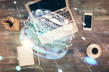 Double exposure of data drawing hologram over topview of study desk background with computer. Concept of Ai.