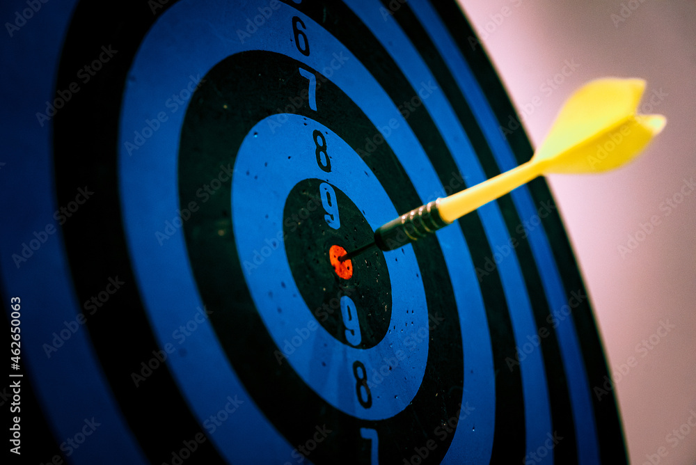 Poster close up shot of the dart arrow hit on bulleyes of dartboard to represent that the business reached 