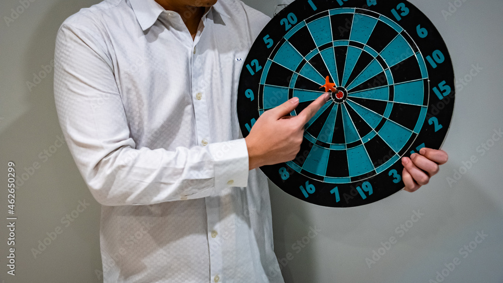 Poster close up shot of the dart arrow hit on bulleyes of dartboard to represent that the business reached 