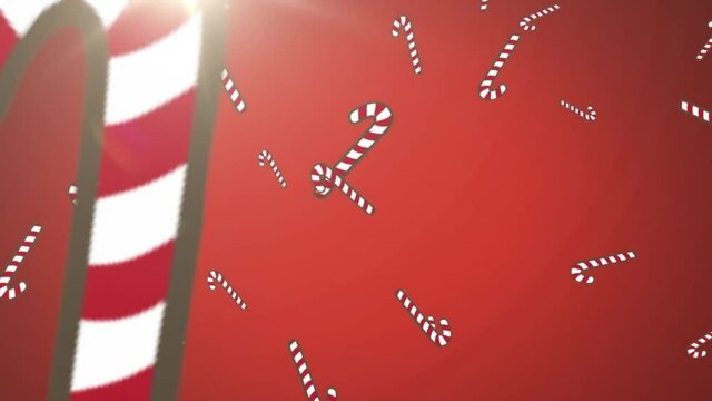Multiple candy cane icons falling against spot of light on red background