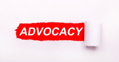 On a bright red background, white paper with a torn stripe and the inscription ADVOCACY