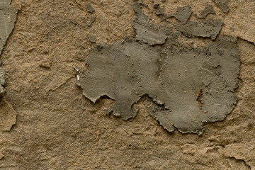 The wall is made of concrete and plaster. Textured plaster wall background, with a patch of concrete repair patch. Background and texture, for creating graphic and photo resources.