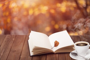 Open Book And Steaming Cup On Wooden Table With Autumn Sunrise Background