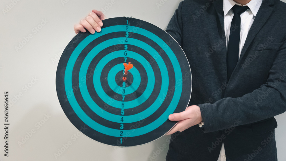 Poster close up shot of the dart arrow hit on bulleyes of dartboard to represent that the business reached 