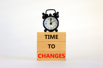 Time to changes symbol. Concept words 'Time to changes' on wooden blocks. Black alarm clock....
