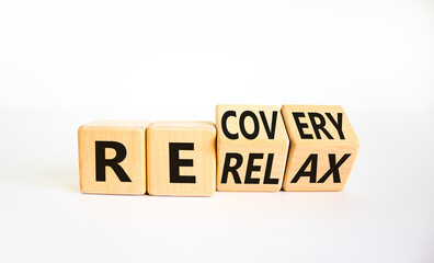 Relax and recovery symbol. Businessman turned cubes and changed the word 'relax' to 'recovery'. Beautiful white table, white background. Business, relax and recovery concept. Copy space.