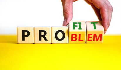 Solving a problem and making profit symbol. Businessman turns wooden cubes, changes the word 'problem' to 'profit'. Beautiful white background. Business, problem to profit concept. Copy space.