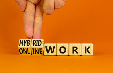Hybrid or online work symbol. Businessman turns cubes and changes words 'online work' to 'hybrid work'. Beautiful orange background. Business, hybrid or online working concept, copy space.