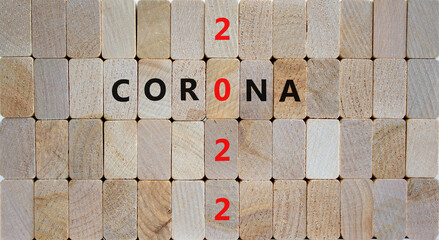 Symbol of covid-19 pandemic in 2022. Wooden blocks with words 'corona 2022'. Beautiful wooden background, copy space. Medical, covid-19 pandemic in 2022 concept.