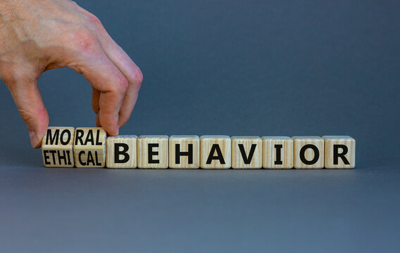 Moral Or Ethical Behavior Symbol. Businessman Turns Cubes, Changes Words Ethical Behavior To Moral Behavior. Beautiful Grey Background, Copy Space. Psychology, Moral Or Ethical Behavior Concept.