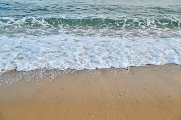 Seascape at sunrise, sea background, foam, sand, dawn.