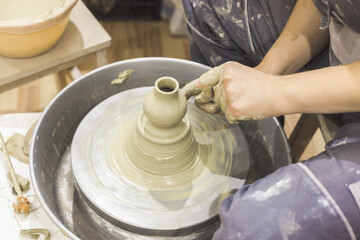Ceramic Artist hands mold clay on pottery wheel. Arts creative workshop.