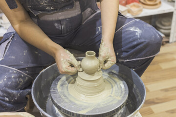 Ceramic Artist hands mold clay on pottery wheel. Arts creative workshop.