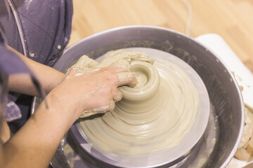 Ceramic Artist hands mold clay on pottery wheel. Arts creative workshop.
