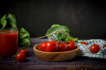 cherry tomatoes and tomato juice on a black background
