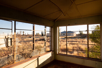 View of the old train station through the broken windows of the abandoned railway town called...