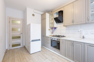 Interior of a modern beige and gray kitchen in a small smart apartment