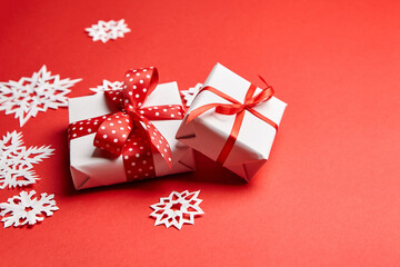 Fototapeta na wymiar Christmas gift boxes with white snowflakes on red