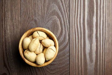 Pecan nuts in bowl on wooden table top view