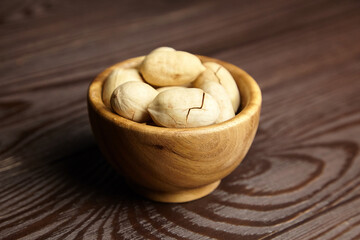 Pecan nuts in bowl on wooden table
