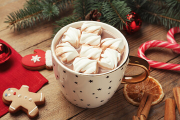 Delicious hot chocolate with marshmallows and Christmas decor on wooden table
