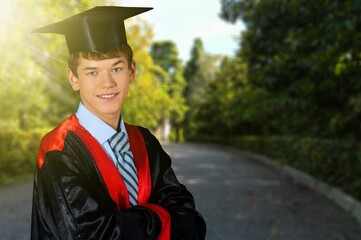 Portrait of handsome male graduate in a graduation robe