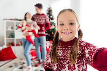 Photo of cheerful small girl take family portrait selfie eve wear sweater in decorated x-mas home indoors
