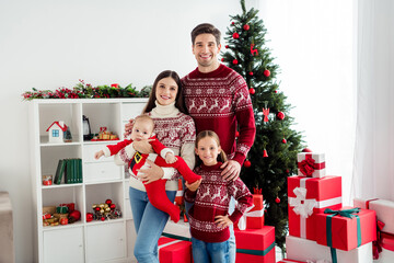 Obraz na płótnie Canvas Photo of trustful positive family cuddle infant small baby enjoy atmosphere wear sweater in decorated x-mas home indoors