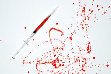 Syringe witn Drops of blood staining spots on a white background, medecine, drug addiction, killing