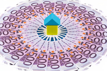 Symbolic small house in the center of a circle of 500 euro banknotes