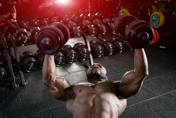 Muscular shirtless man working out with heavy barbells. Handsome bodybuilder with perfect abs? shoulders.
