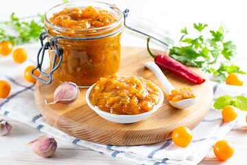 Spicy sauce from yellow plums, garlic, hot pepper, cilantro, dill and mint, known as tkemali. Georgian cuisine. Preserving
