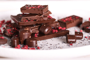 chocolate with dry raspberries lies on a light background